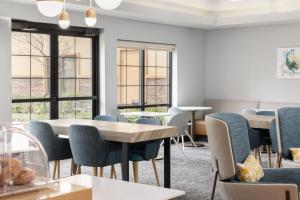 a waiting room with tables and chairs and windows at TownePlace Suites by Marriott Sacramento Roseville in Roseville