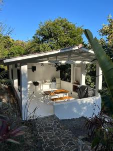 een witte pergola met een tafel en een patio bij Guest house in Altos del Maria in Sorá