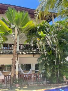 a house with palm trees in front of it at Kite Dream Cumbuco Apartments 60 & 120qm in Cumbuco