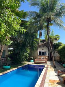 a pool in front of a house with palm trees at Kite Dream Cumbuco Apartments 60 & 120qm in Cumbuco