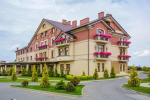 ein großes Gebäude mit rosa Blumen auf den Balkonen in der Unterkunft Panska Gora in Lwiw