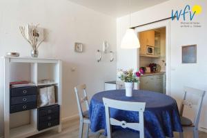 a dining room with a table and chairs and a kitchen at Ferienhaus Seeblick - Wohnung 96 in Borkum +20 photos