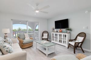 a living room filled with furniture and a flat screen tv at Gorgeous Top Floor Beach Condo at Breakers West in Sanibel