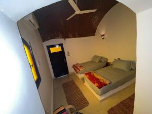 Zimmer mit 2 Betten und einem Deckenventilator in der Unterkunft king kassem nubian guest house in Assuan