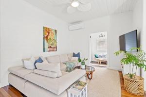 un salon avec un canapé et une télévision dans l'établissement 34 Woodburn Street, à Evans Head