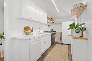 une cuisine blanche avec des armoires blanches et une plante dans l'établissement 34 Woodburn Street, à Evans Head