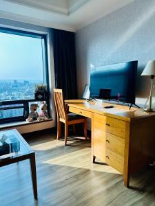 een kamer met een bureau en een groot raam bij Luxury House in Taichung