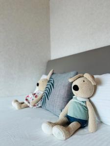 twee knuffelteddyberen op een bed bij Luxury House in Taichung