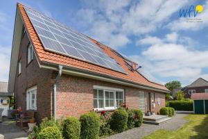 a house with solar panels on the roof at Villa Robinson - Ferienwohnung Luv in Borkum