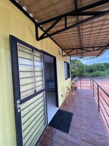 een houten veranda met een deur en een terras bij Suíte Contêiner Roraima in Boa Vista