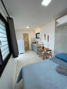 een slaapkamer met een bed en een keuken met een tafel bij Suíte Contêiner Roraima in Boa Vista