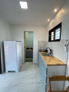 een keuken met een witte koelkast en een wastafel bij Suíte Contêiner Roraima in Boa Vista