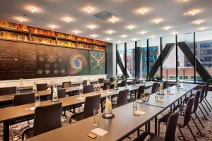 a conference room with tables and chairs and a chalkboard at Hotel EMC2, Autograph Collection in Chicago