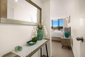 a room with a mirror and a table with flowers at Pacific Towers Beach Resort in Coffs Harbour