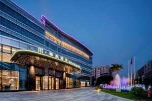 um grande edifício com muitas janelas em Mehood Elegant Hotel Guangzhou Baiyun Airport Huadu Cultural Tourism City em Huadong