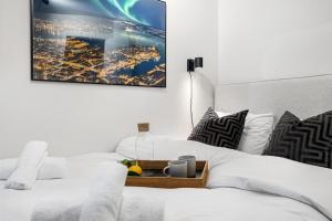 een witte slaapkamer met een bed en een houten dienblad. bij King bed - Behind Bryggen - Renovated des 23 in Bergen