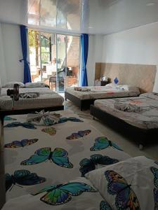 um quarto com três camas com borboletas em Quinta Guairabamba em Melgar