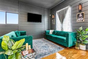 sala de estar con sofá verde y TV en The Magic House Spacious Home Central To All!, en Nueva Orleans