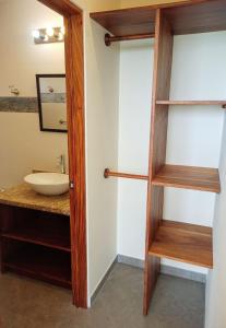 een badkamer met een houten deur en een wastafel bij VILLA SIMONE FRENCH ECOLODGE in Tilarán