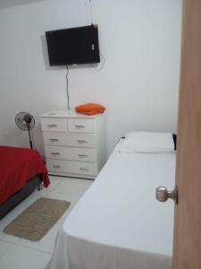 a bedroom with a bed and a flat screen tv at Hostel Campoamor in Medellín