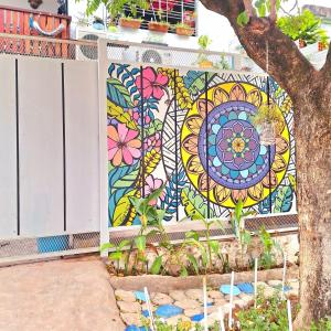 a colorful mosaic mural on the side of a fence at La Petite Maison in Asuncion