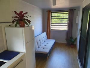 a living room with a couch and a refrigerator at Les Maripas T2 in Rémiré