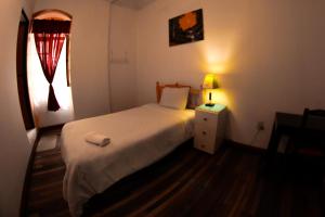 a bedroom with a bed and a lamp on a table at Vibes Aurik in Quito