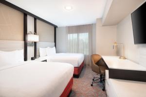 a hotel room with two beds and a desk at Springhill Suites by Marriott Conyers in Conyers