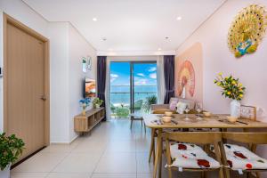 - un salon avec une table et des chaises offrant une vue sur l'océan dans l'établissement The Sóng Apartment Vũng Tàu - Oliu Homestay - Free Hồ Bơi Vô Cực, à Vung Tau