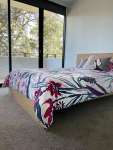 een slaapkamer met een bed met een bloemenbed bij Brand New Brilliant Location Heart of Inner South in Kingston 