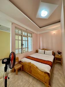 una camera con un grande letto e una finestra di Nhà nghỉ Nghĩa Nhân a Da Lat