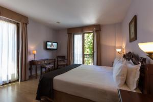 a bedroom with a bed and a television at Ayre Hotel Alfonso II in Oviedo