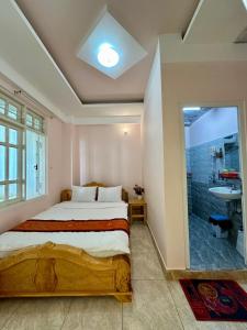 - une chambre avec un lit et une salle de bains pourvue d'un lavabo dans l'établissement Nhà nghỉ Nghĩa Nhân, à Đà Lạt