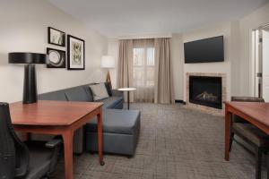 een woonkamer met een bank en een open haard bij Residence Inn by Marriott Fayetteville Cross Creek in Fayetteville