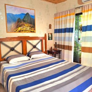 a bedroom with a blue and white bed and a window at La Petite Maison in Asunción