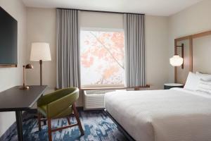 a hotel room with a bed and a desk and a window at Fairfield by Marriott Inn & Suites Sioux Center in Sioux Center
