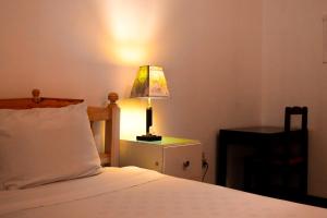 a bedroom with a bed with a lamp on a night stand at Vibes Aurik in Quito