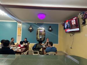 a group of people sitting at tables in a restaurant at Hotel Elegant in Cajamarca