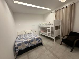 1 dormitorio con 1 cama, 1 litera y 1 silla en Casa Conteiner, en Itaboraí