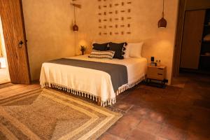 Un dormitorio con una cama grande con almohadas. en La Paranera Hotel & Relax en Comala