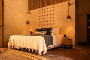1 dormitorio con 1 cama con colcha blanca en La Paranera Hotel & Relax en Comala