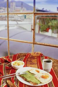 a table with a plate of eggs and coffee on it at Vibes Aurik in Quito