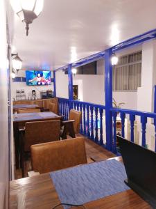 uma sala de jantar com mesas e cadeiras e uma televisão em El Ave Azul Boutique Hotel Cusco em Cusco