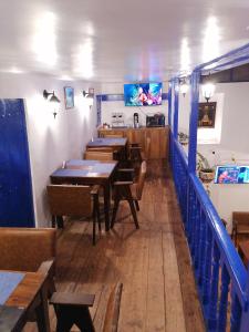 a dining room with wooden tables and blue railing at El Ave Azul Boutique Hotel Cusco in Cusco