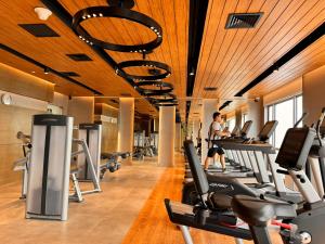 a gym with many treadmills and a person in the background at Luxxe interior design condo @ Novotel Suites Manila - Acqua in Manila