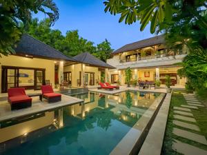an exterior view of a house with a swimming pool at Villa Bugis Abimanyu Seminyak in Seminyak