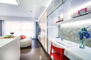 a kitchen with a white counter and a red chair at V Wanchai in Hong Kong