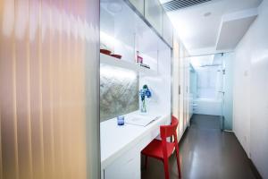 a bathroom with a white sink and a red chair at V Wanchai in Hong Kong