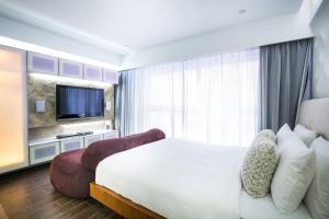 a hotel room with a bed and a tv at V Wanchai in Hong Kong