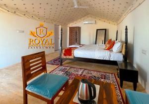 a bedroom with a bed and a table and chairs at Royal Empire Resort Jaisalmer in Jaisalmer